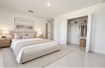 Neutral-toned ceramic tile flooring, recessed ceiling lighting, and a bi-fold closet door with integrated wire shelving