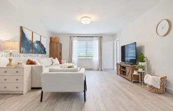 Neutral interior space featuring wood-finish flooring, a single-window configuration with horizontal blinds, and a flush-mount circular ceiling light fixture