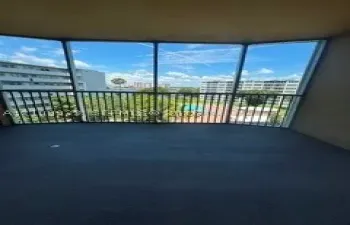 Covered balcony featuring multi-panel glass enclosures and metal railings