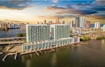 Waterfront high-rise building featuring extensive glass balconies, integrated boat slips, and deep-water access