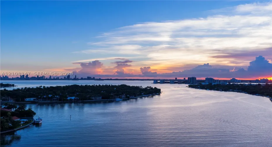 expansive bay views deep water access,skyline,open bayunder a sunset backdrop
