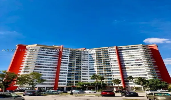 High-rise residential building featuring a tiered architectural design, reinforced concrete exterior, multiple levels of private balconies, and glass panel railings