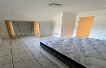 Ceramic tile flooring, built-in shelving unit, multi-panel interior door, and flush-mount ceiling light