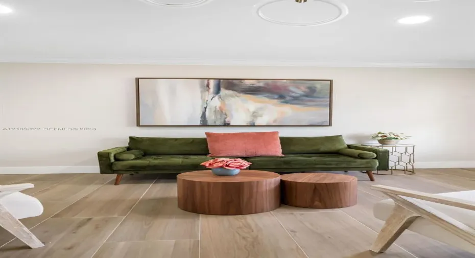 Wood-finish tile flooring, neutral wall palette, and recessed circular ceiling light fixtures