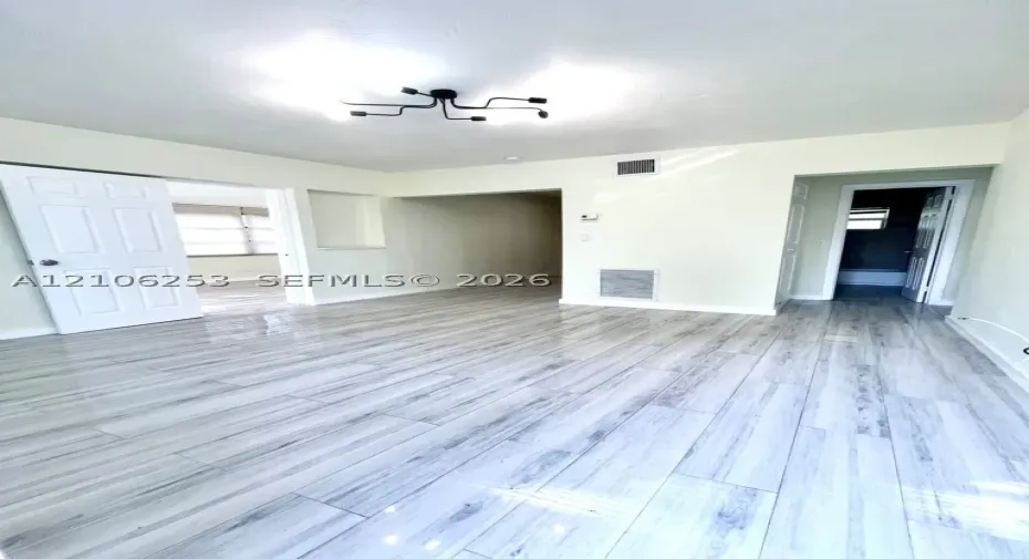 Porcelin Wood-finish flooring, matte black multi-arm ceiling fixture, recessed wall niche, and six-panel interior doors