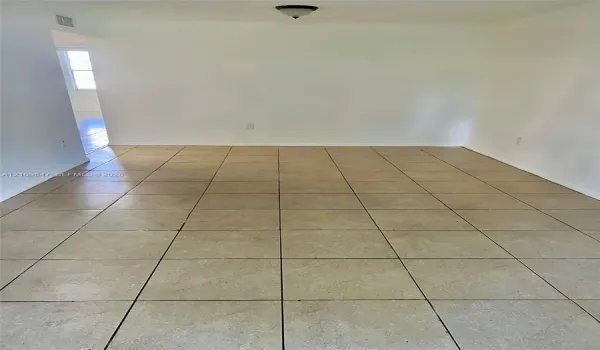 Interior space featuring neutral wall tones, large-format ceramic tile flooring, and a flush-mount overhead light fixture
