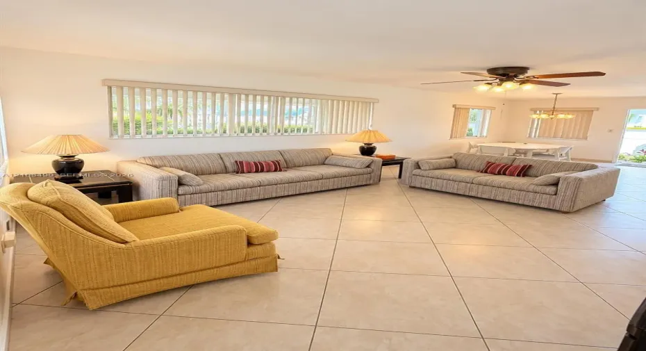 Neutral ceramic tile flooring, ceiling fan with integrated lighting, and vertical window blinds