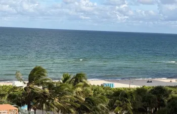 Oceanfront expanse with direct shoreline access, expansive sandy beach, and mature coastal palm trees