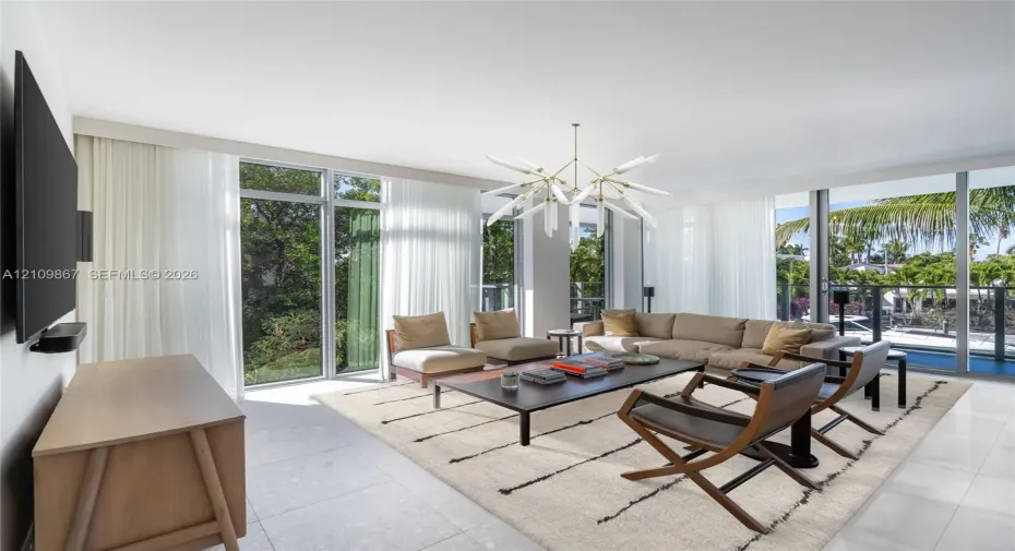 Floor-to-ceiling windows, large-format tile flooring, and a multi-arm geometric chandelier