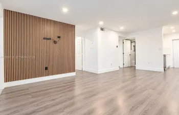 Interior space featuring a vertical wood-slat accent wall, wood-finish flooring, recessed lighting, and multi-panel interior doors