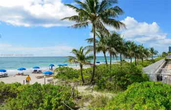 Direct access to sandy beach, perimeter security fencing, and mature tropical landscaping