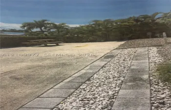 RV Lot featuring concrete pad decorative stone borders, and mature palm trees