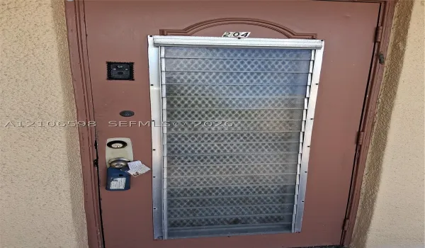 Entry door featuring a textured finish, integrated louvered glass window panel with security grille, and a built-in electronic doorbell system