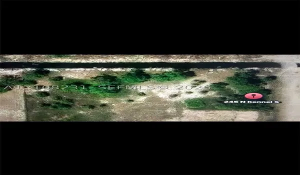 Aerial view of the parcel featuring mature trees, native vegetation, and a natural waterway boundary