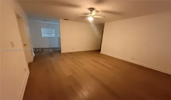 Neutral wall palette, wood-finish flooring, and ceiling fan with integrated lighting