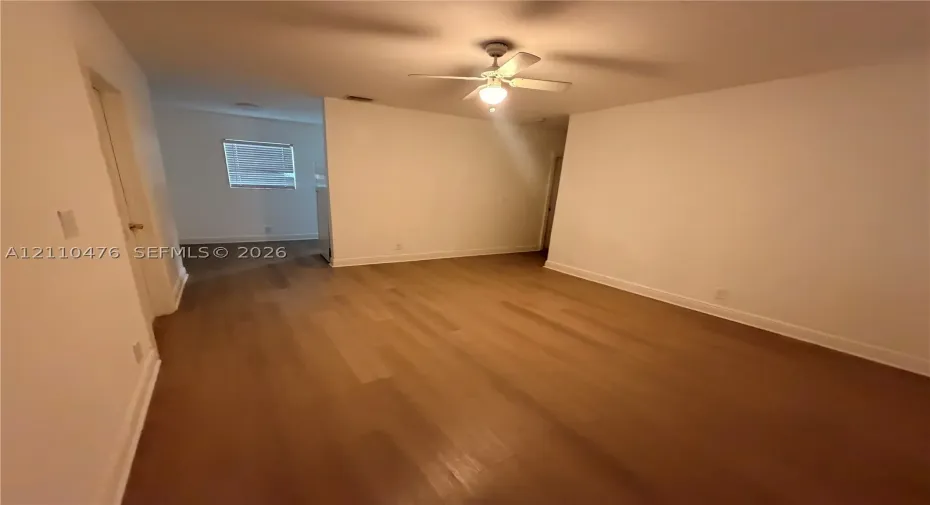 Neutral wall palette, wood-finish flooring, and ceiling fan with integrated lighting