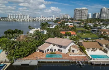 Waterfront property featuring a private boat dock, in-ground swimming pool, masonry exterior, and tile roof