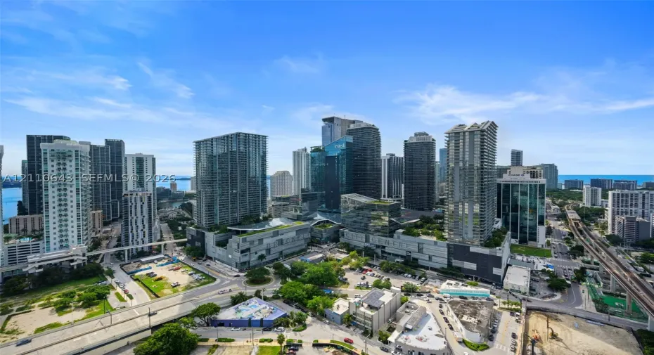 Aerial perspective featuring a dense metropolitan skyline, high-rise architectural density, and urban street infrastructure