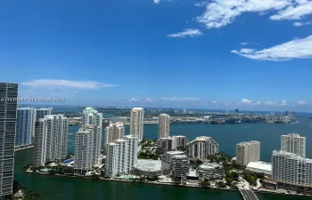 High-altitude perspective featuring expansive water frontage, coastal scenery, and a panoramic urban skyline