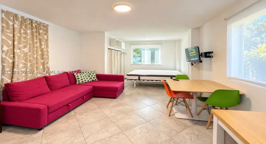 Interior space featuring large-format ceramic tile flooring, dual windows, and recessed ceiling lighting