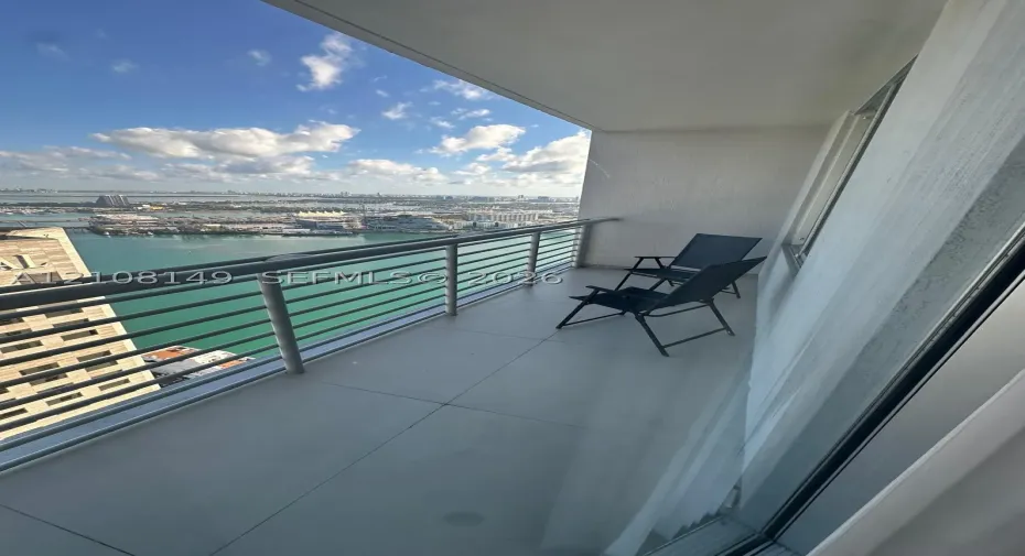 Private balcony featuring large-format tile flooring and a metallic horizontal railing