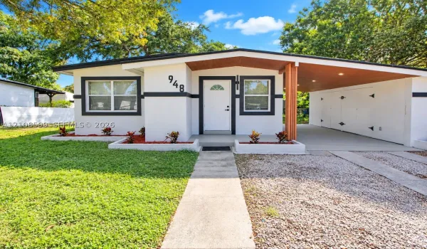 Mid-century exterior featuring a recessed entry, covered carport, wood-paneled ceiling, concrete walkway, and raised planting beds