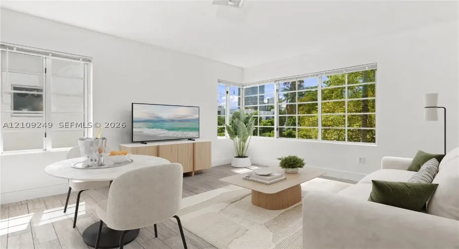 Living area featuring large multi-pane windows, neutral wall finishes, and wood-finish flooring