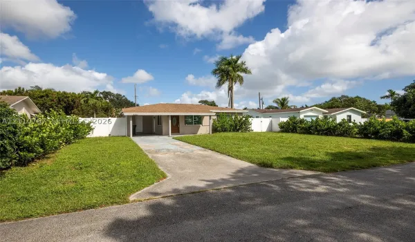 Single-story exterior featuring a hip roof, covered front entryway, concrete driveway, and white vinyl privacy fencing