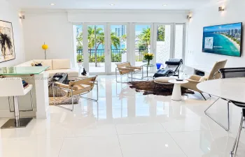 Open-concept living space featuring high-gloss tile flooring, recessed lighting, and expansive glass paneled doors leading to a private terrace