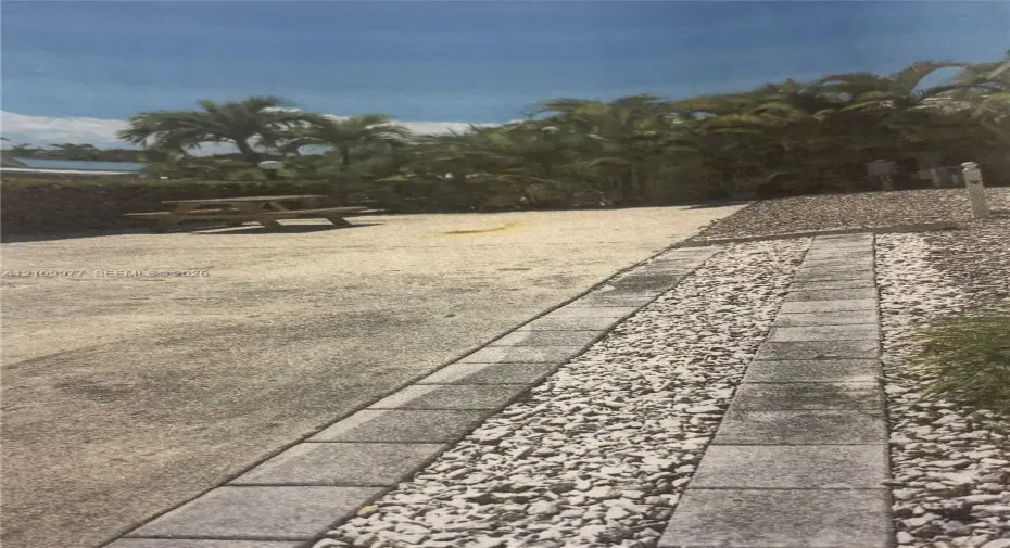RV Lot featuring concrete pad decorative stone borders, and mature palm trees