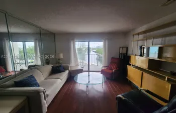 Wood-finish flooring, full-wall mirrored accent, sliding glass door, and built-in wood shelving unit