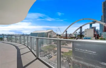Expansive curved balcony featuring tile flooring and a glass railing