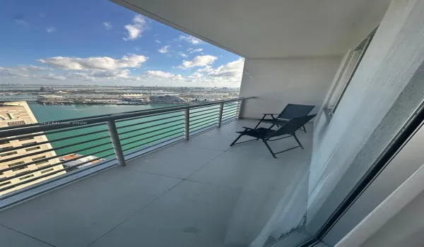 Private balcony featuring large-format tile flooring and a metallic horizontal railing