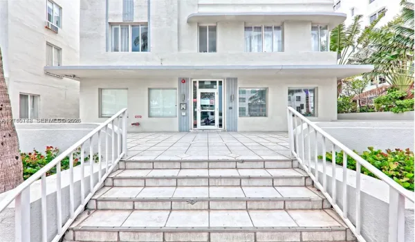 Art Deco exterior featuring a symmetrical facade, tiled entryway steps, and metal railings