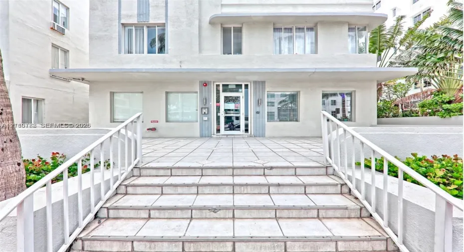 Art Deco exterior featuring a symmetrical facade, tiled entryway steps, and metal railings