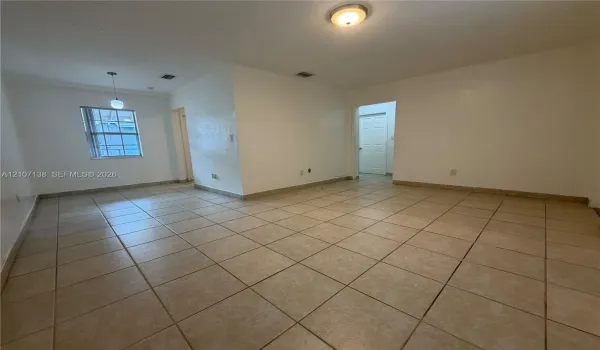 Interior space featuring neutral wall paint, large-format tile flooring, a hanging pendant light, and a flush-mount ceiling fixture