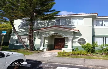 Two-story exterior featuring a covered entryway with spiral columns, a gabled roofline, an oval accent window, and a tile roof