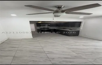 Large-format tile flooring, recessed lighting, and a modern ceiling fan with a central light fixture