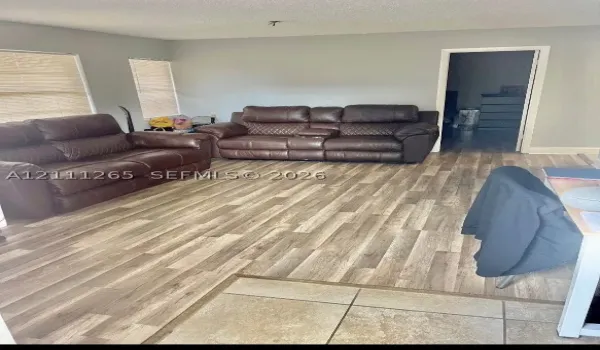 Neutral interior featuring wood-finish flooring, light gray wall paint, and horizontal window blinds