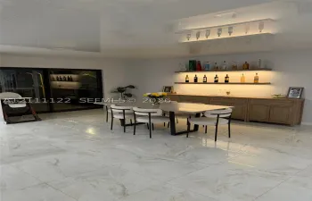 Large-format stone-finish floor tiling, integrated custom cabinetry with wood finish, dual wall-mounted floating shelves with recessed under-shelf lighting, and black-framed sliding glass doors