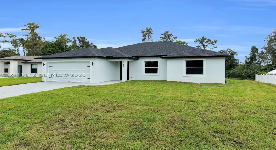 Front exterior of this new construction single-story home with stucco finish, shingle roof, and 2-car garage.