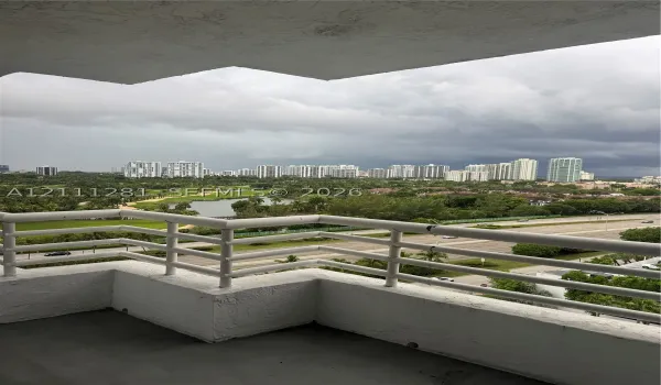 Covered balcony featuring white metal railings and concrete flooring