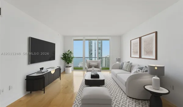 Living area featuring wood-finish flooring, floor-to-ceiling glass panel doors, and access to a private balcony