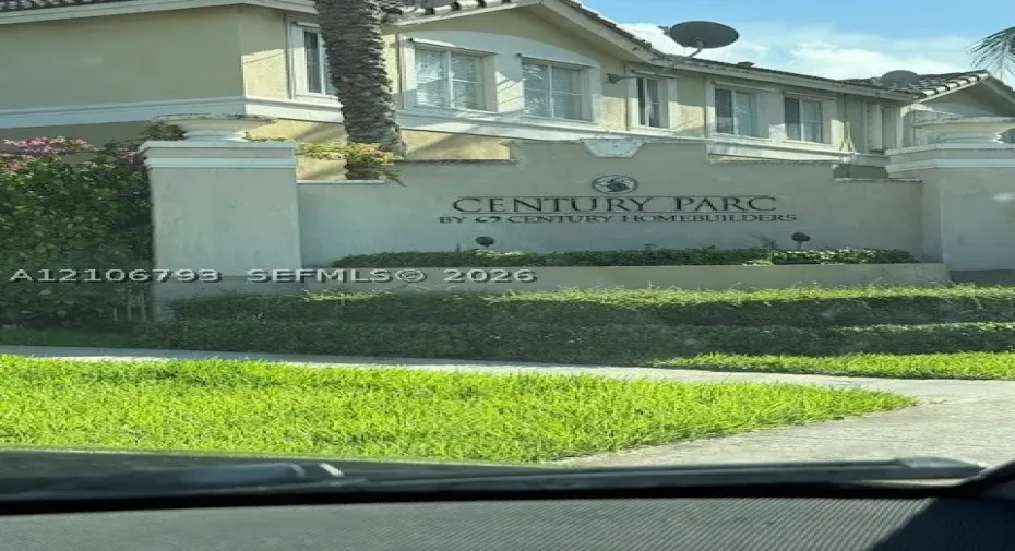 Stucco community entrance monument with concrete pilasters and integrated landscaping