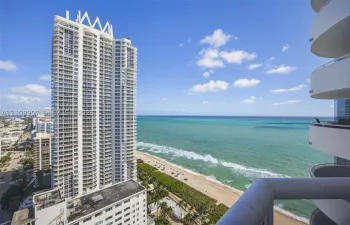 Expansive 29th floor views from covered balcony with metal railing, floor-to-ceiling glass windows, and oceanfront, intracoastal and Biscayne Bay exposures.