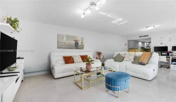 Living area featuring polished tile flooring, multi-directional track lighting, and a neutral color palette