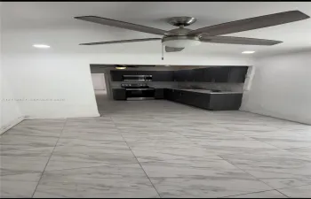Large-format tile flooring, recessed lighting, and a modern ceiling fan with a central light fixture