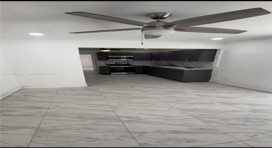 Large-format tile flooring, recessed lighting, and a modern ceiling fan with a central light fixture