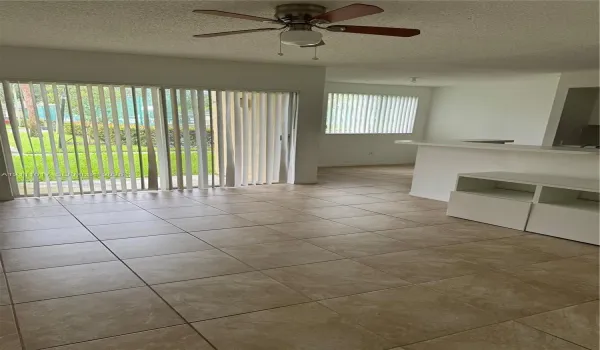 Ceramic tile flooring, sliding glass patio door, built-in breakfast bar, and ceiling fan