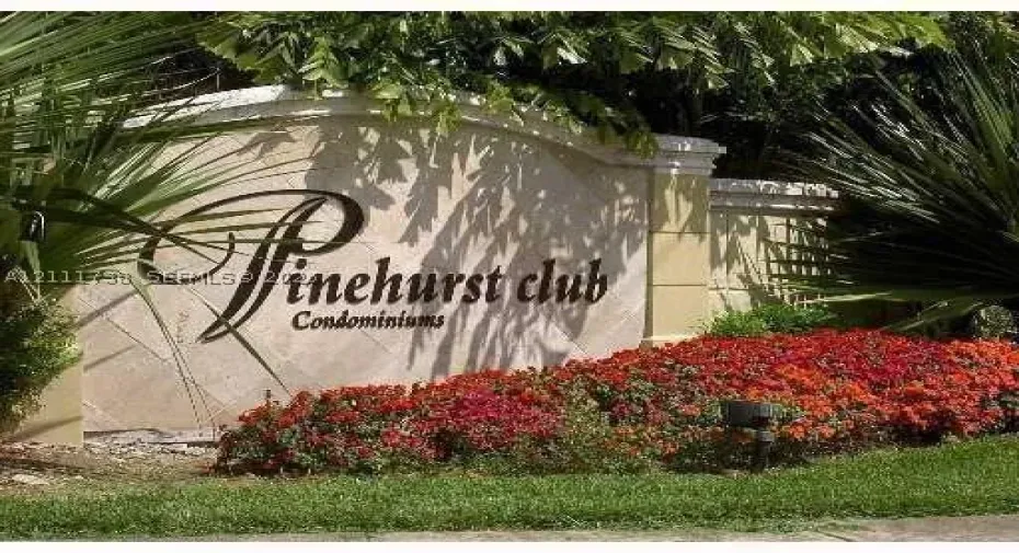 Stone-clad monument signage featuring architectural detailing, accented by manicured landscaping and mature foliage
